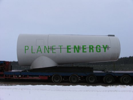 Transport eines Windkraftgenerators mit dem Planet Energy-Label auf einem Anhänger.