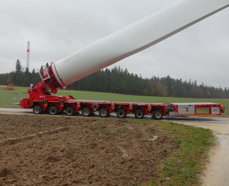 Transport eines Rotorblatts für Windkraftanlagen auf rotem Fahrzeug